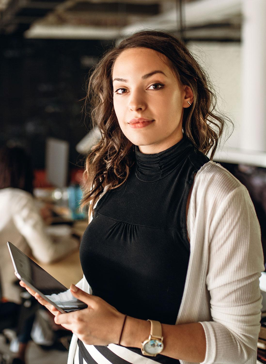 Woman holding tablet using CentralSquare computer aided dispatch software solution.