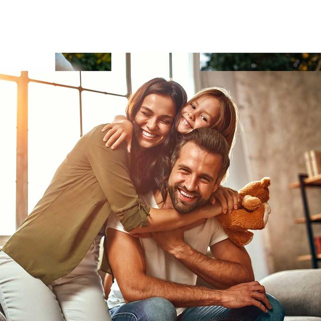 Happy family hugging while posing for photo