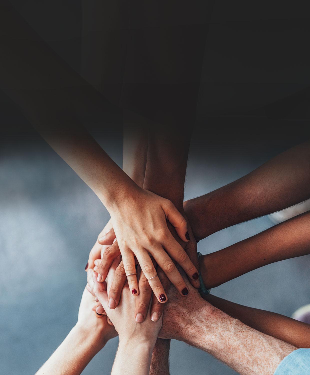 Many hands together on top of one another, to visualize teamwork.