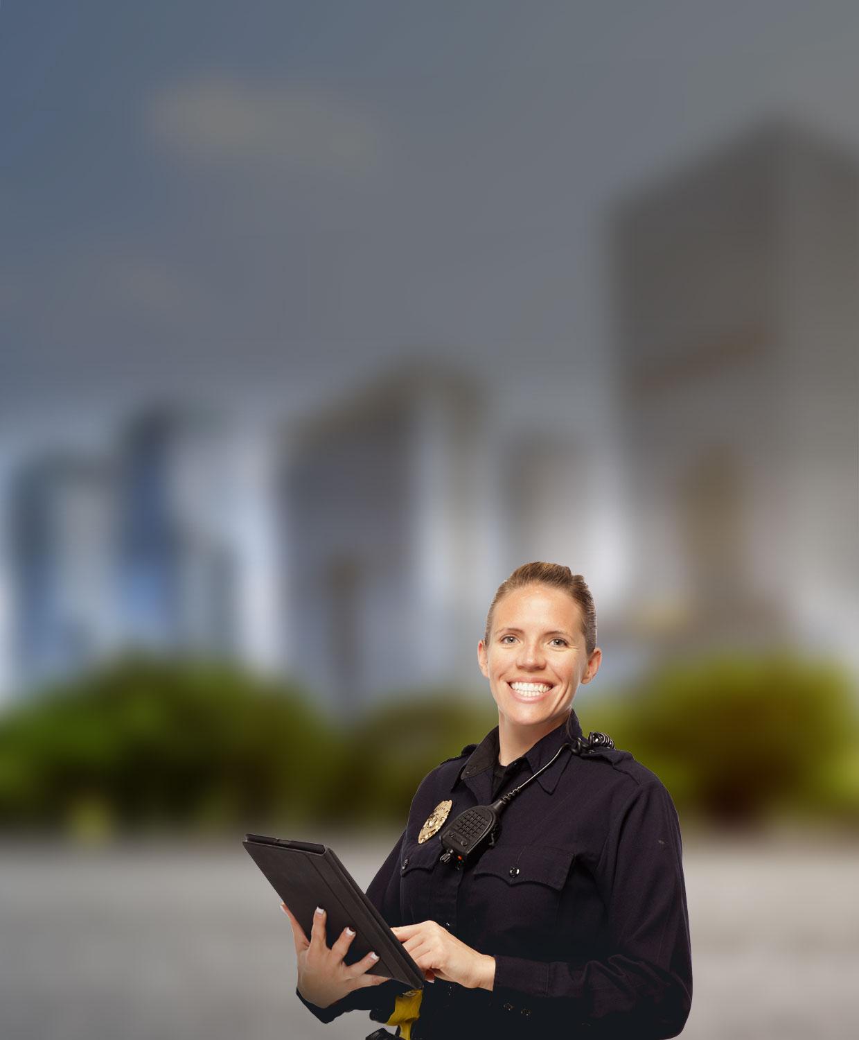 A female officer is smiling as she holds a tablet in her hands.