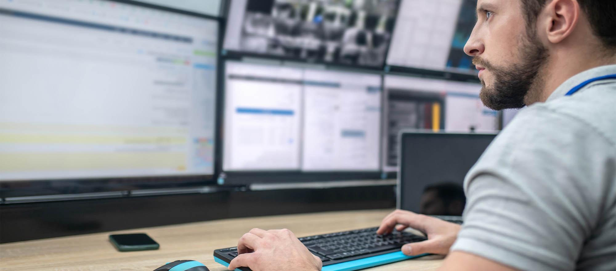 A 911 dispatcher taking calls at a call center, typing on the computer.