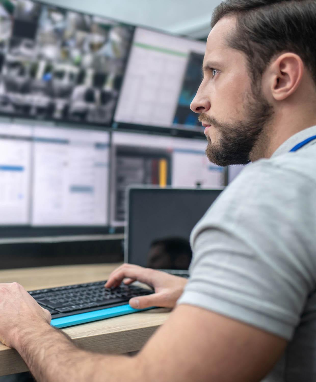 A 911 dispatcher taking calls at a call center, typing on the computer.