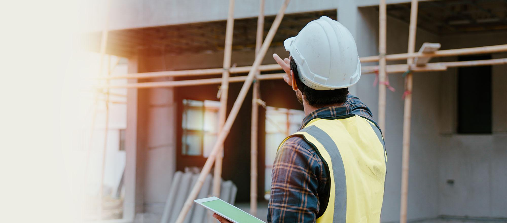 A background image of an code enforcement officer at a building site with a tablet device.