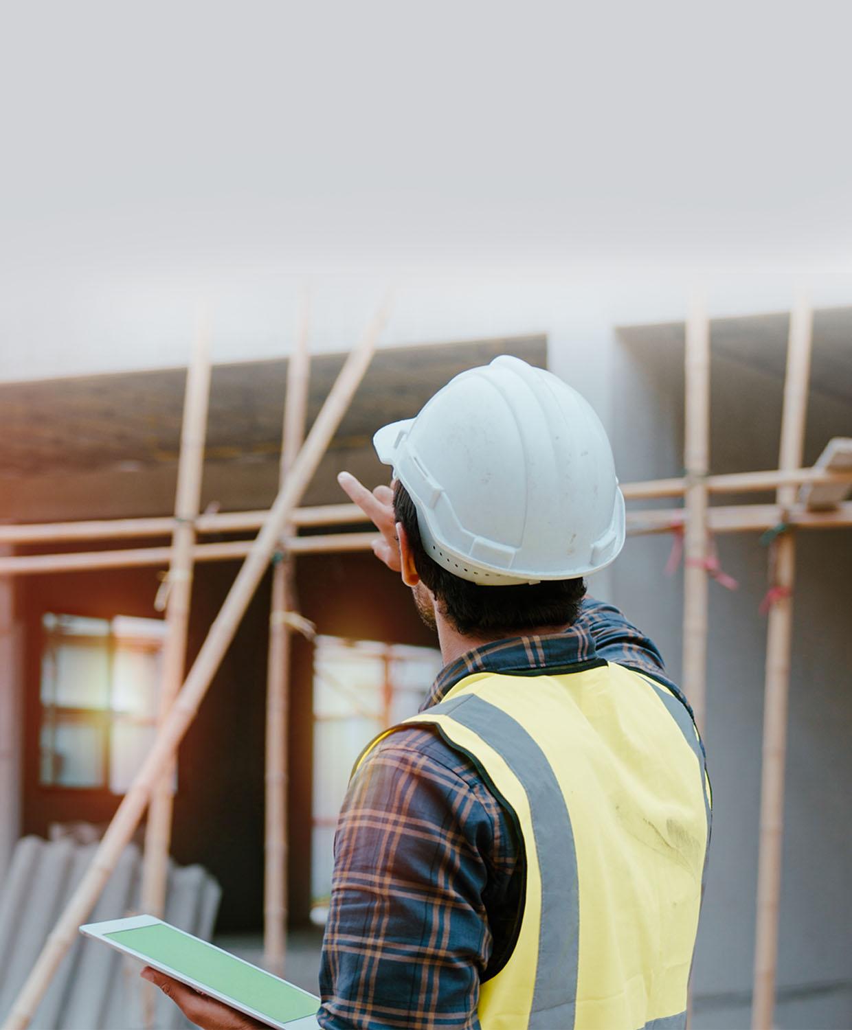 A background image of an code enforcement officer at a building site with a tablet device.