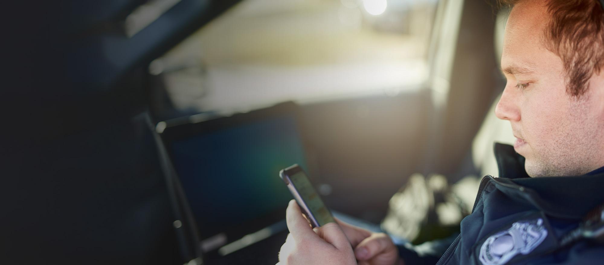 A background image showing an officer on his mobile phone.