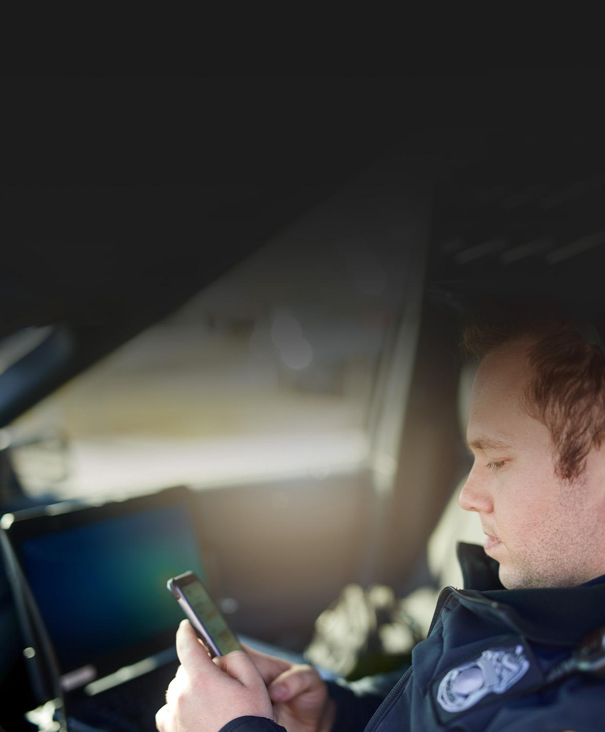 A background image showing an officer on his mobile phone.