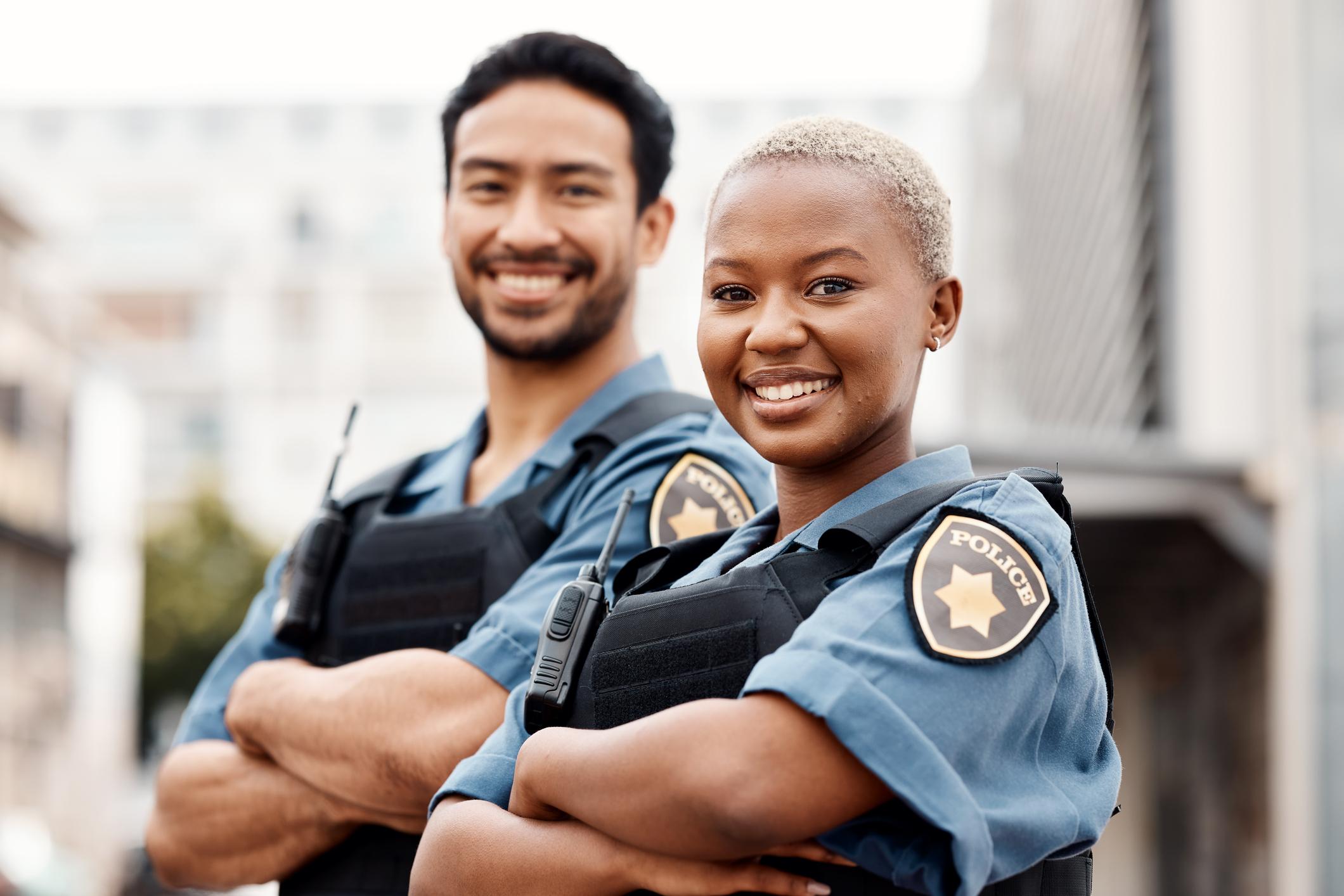 two police officers smiling with arms crossed