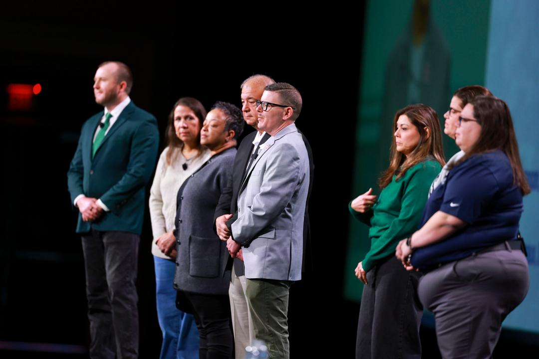 8 people standing on a stage
